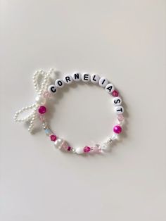 a bracelet with the word correlia written in white letters and pink beads on it