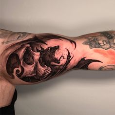 a man's arm with tattoos on it and an image of a dragon in the middle