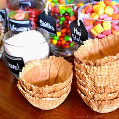 several baskets filled with candy sitting on top of a wooden table next to other candies