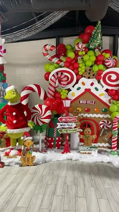 an assortment of christmas decorations and candy canes on display in front of a tree