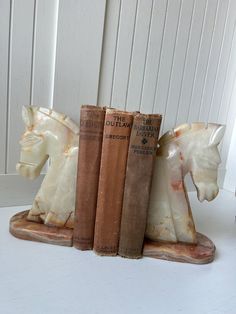 three bookends made out of old books sitting on top of a white table