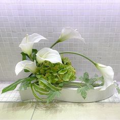 a white flower arrangement sitting on top of a counter