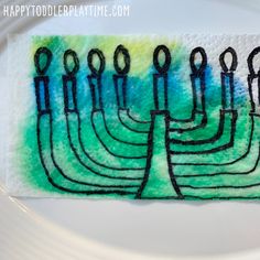 a white plate topped with a painting of menorah