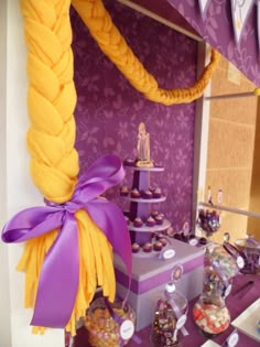 a purple and yellow dessert table with cupcakes