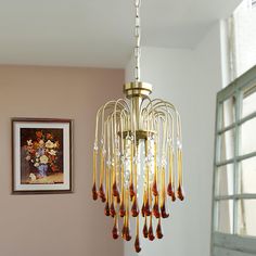 a chandelier hanging from the ceiling in a room with pink walls and windows