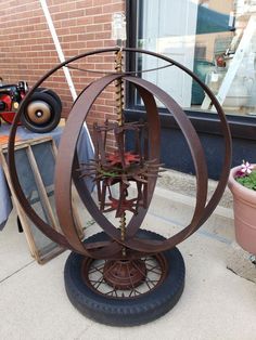 an outdoor clock made out of old tires on the sidewalk in front of a building