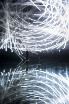 a man standing in front of a mirror with white lights on it's face