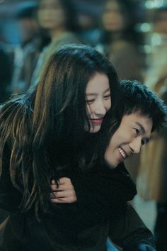 two people are smiling and hugging each other