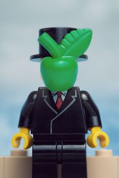 a lego man in a suit and top hat with an apple on it's head