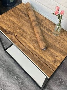 a vase with flowers on top of a wooden table