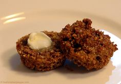 two desserts on a white plate with cream in the middle and brown crumbs