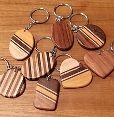 six wooden keychains with different designs on them sitting on top of a table