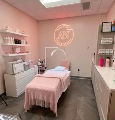 a pink room with a bed, desk and shelves on the wall next to it