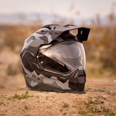 a helmet sitting on top of a dirt field