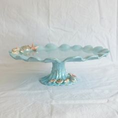 a blue cake plate with seashells on it