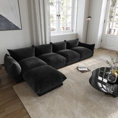 a living room with a couch, coffee table and large window in it's center