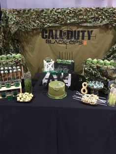 a table topped with cake and desserts covered in green frosted icing on top of a black table cloth