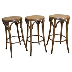 three wooden stools with wicker seats on white background