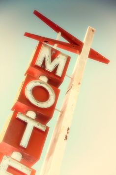 an old motel sign that has been painted red and white with the word motel on it