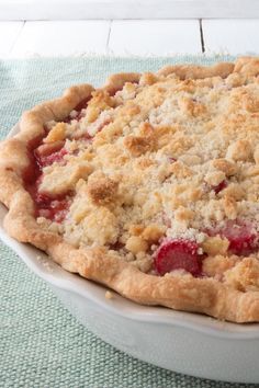 a pie sitting on top of a white plate covered in crumbly toppings