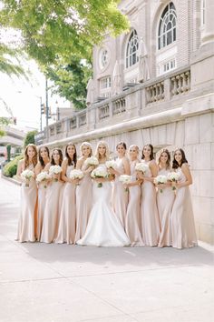 a group of bridesmaids standing in front of a building