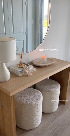 a table with two stools and a round mirror