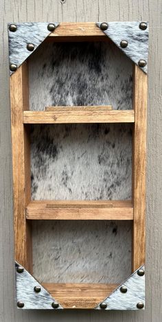 a wooden shelf with metal rivets on the top and two shelves below it