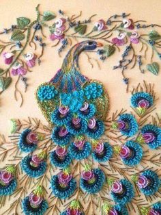 a peacock made out of crochet is shown on a wall with flowers and leaves