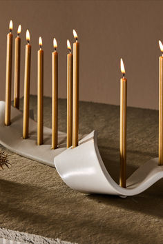 there are many candles that are in the candle holder on the table top, and one is lit