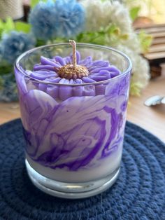 a purple and white candle sitting on top of a blue mat