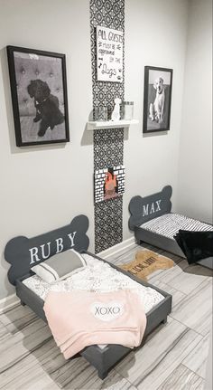 two beds in a room with pictures on the wall