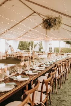 an outdoor tent with tables and chairs set up for dinner