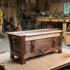 a wooden box sitting on top of a table in a room filled with woodworking tools