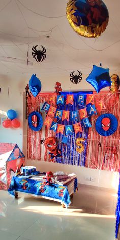 a room with spiderman decorations and streamers