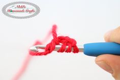 someone is crocheting red yarn with a blue needle