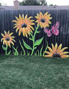 a fence painted with sunflowers and butterflies