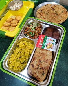 two trays filled with different types of food on top of a green countertop