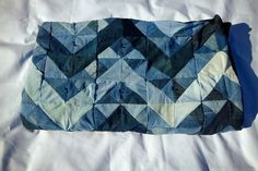 a piece of cloth that is on top of a white sheet with blue and black designs