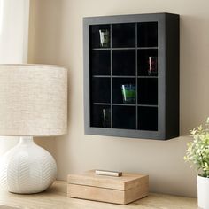 a table with a lamp and some drinks on it next to a wall mounted shelf