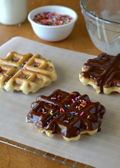 three chocolate covered waffles sitting on top of a table