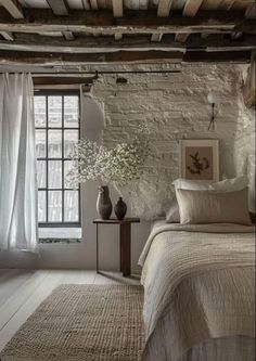 a bedroom with white walls and wooden beams