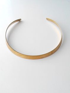 So chic and sleek. Add some oomph to your look with this simple but super elegant choker. The gold tone choker looks great on any complexion and is an eye-catching statement piece that anyone can pull off ! The model has a neck circumference approx 15 inches. The choker has a circumference approx 14 inches. One size, fit most. The choker comes without clasp. Contains no lead or nickel. Do not perfume over it or subject it to any liquid substances. I love the pure metal. But over time, metal will Minimalist Gold Choker Jewelry, Trendy Adjustable Gold Choker, Gold Minimalist Choker, Chic Gold Choker, Formal Brass Choker Jewelry, Minimalist Brass Choker Jewelry, Elegant Round Brass Choker, Modern Adjustable Gold Choker, Minimalist Gold Metal Choker