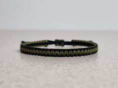 a black and green string bracelet on a table