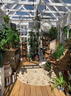 a room filled with lots of potted plants inside of a glass roofed building