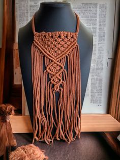 an orange crocheted scarf on a mannequin