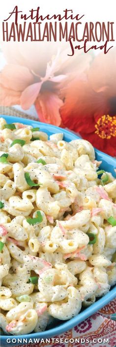 a blue bowl filled with macaroni salad on top of a colorful table cloth