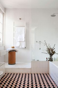 a white bathroom with black and white checkered flooring on the walls, tub, toilet and sink