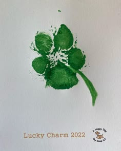 a green flower with the words lucky charm 2012 written in white ink on a piece of paper