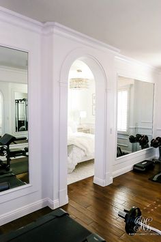 an exercise room with mirrors and treadmills