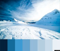 a snow covered mountain with blue skies and white clouds in the background is a panoramic photo